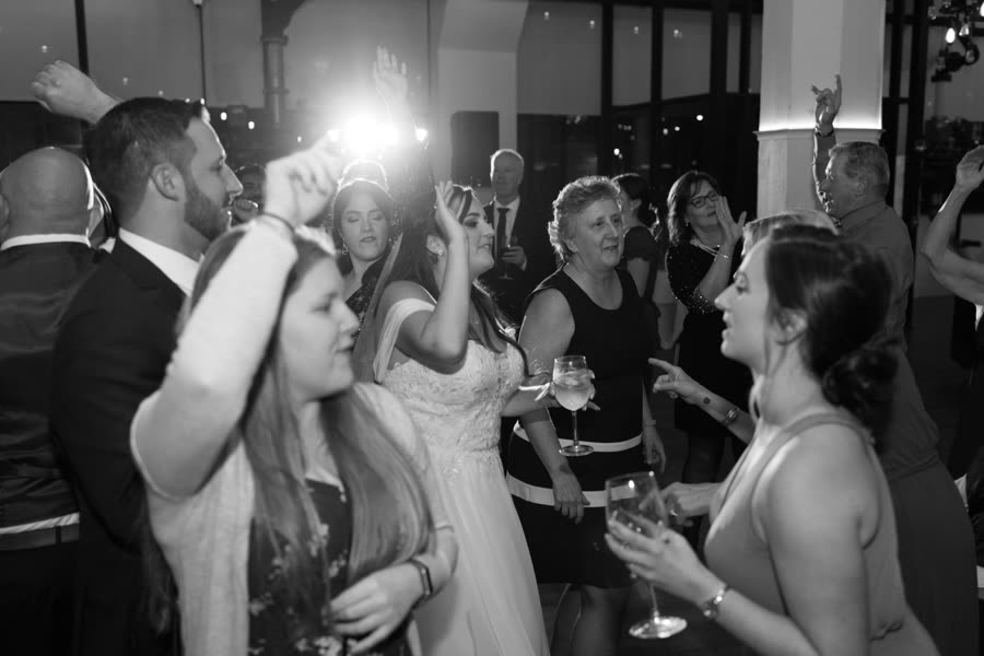 Bride and guests dancing, black and white
